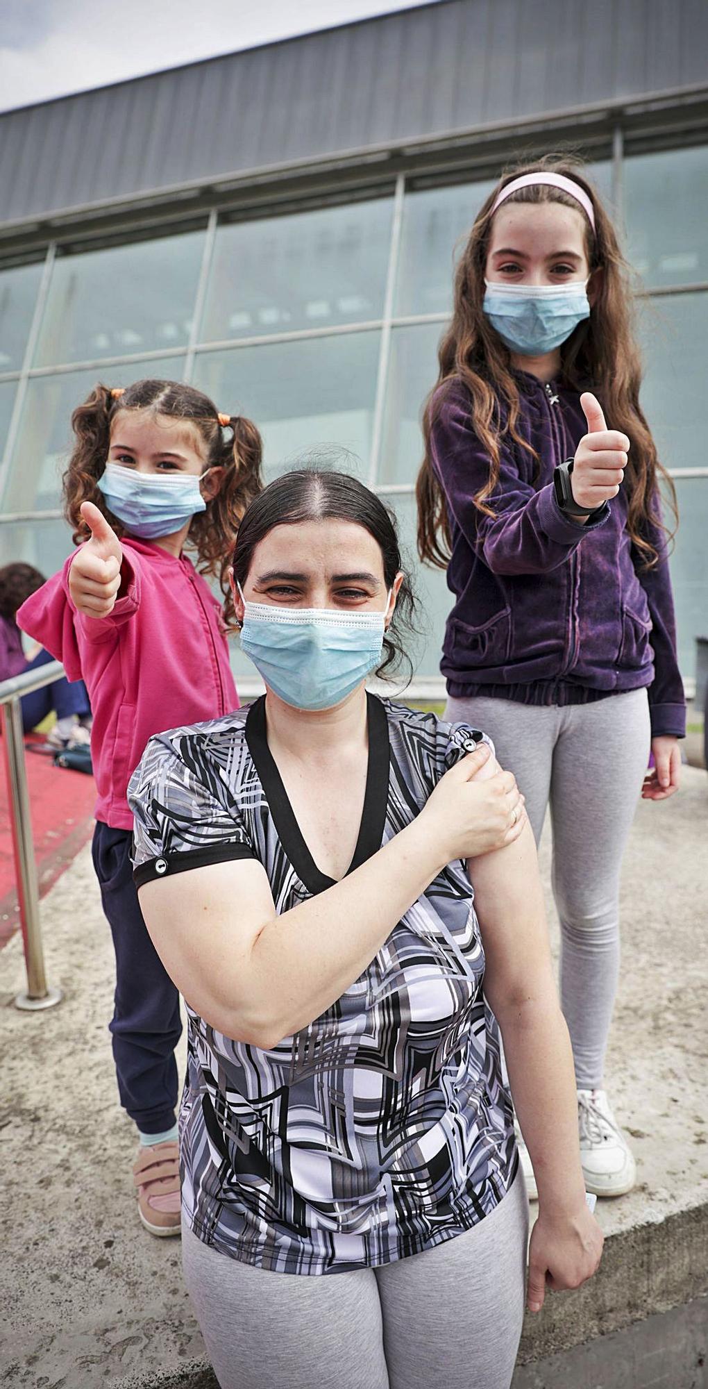 Natalia Pérez Rodríguez, recién vacunada, en el HUCA, y con ella sus hijas Érika y Mireia Salas Pérez. | Irma Collín