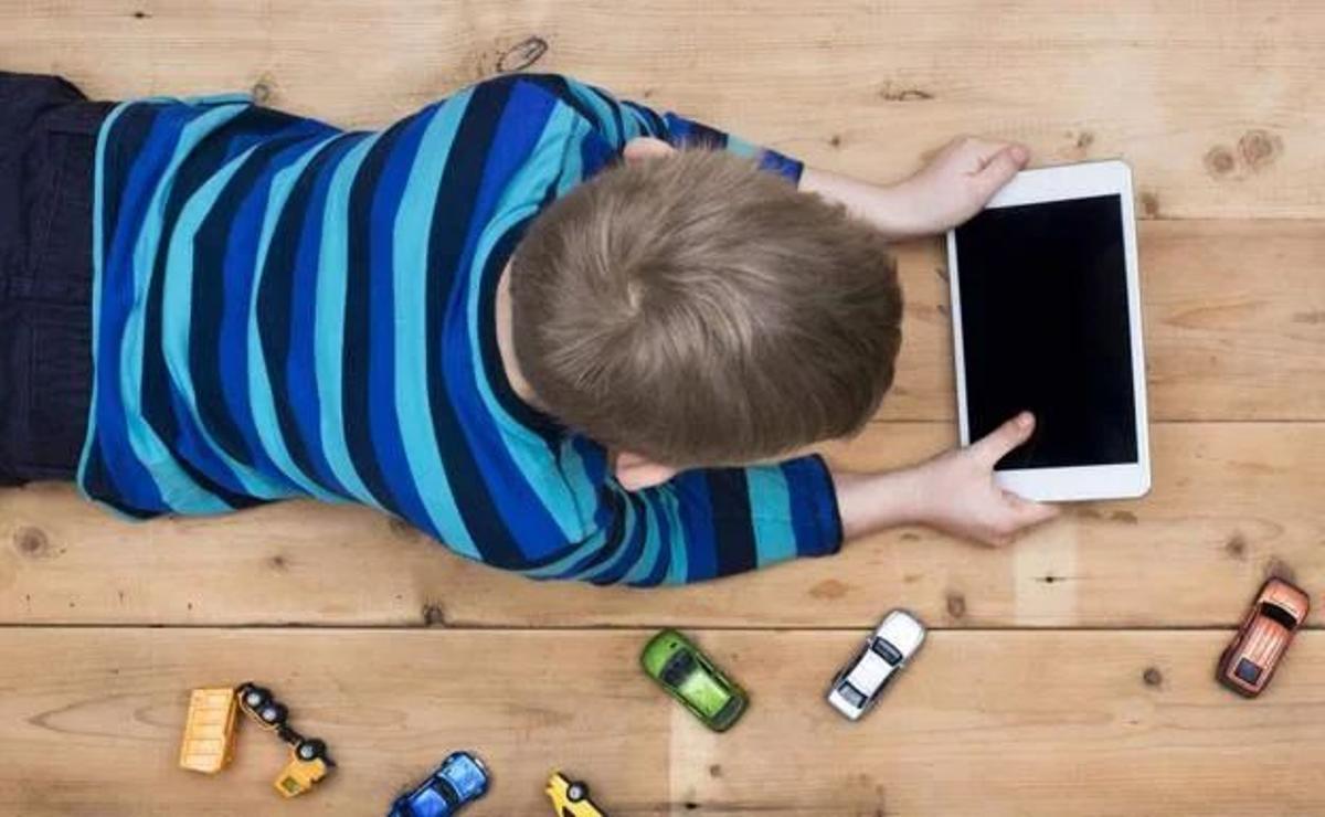 Un niño, con una tablet en casa.