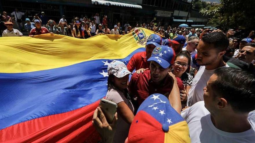 El líder opositor Henrique Capriles se deja fotografiar junto a una enseña venezolana durante el plebiscito opositor. // Efe