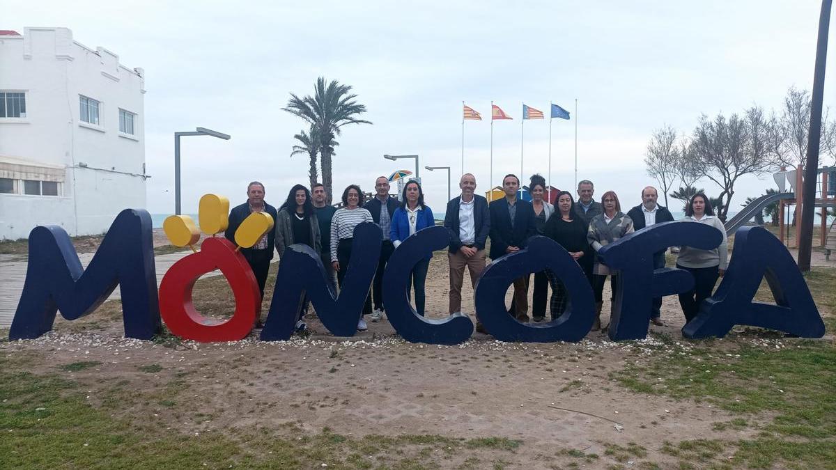 Foto de familia de los integrantes de la lista electoral del PP de Moncofa, junto al letrero turístico de la zona de la playa.