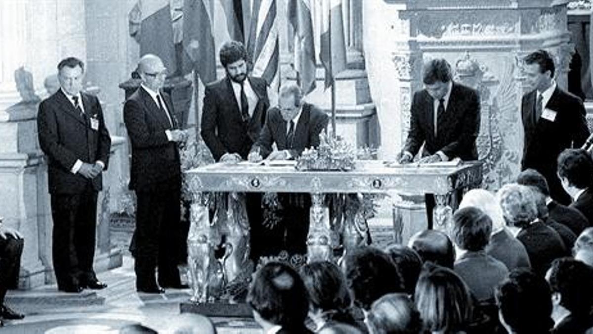 Felipe González y Fernando Morán firman el acta de adhesión ante la mirada de Manuel Marín (con barba) y el rey Juan Carlos, en el Palacio Real de Madrid, el 12 de junio de 1985.