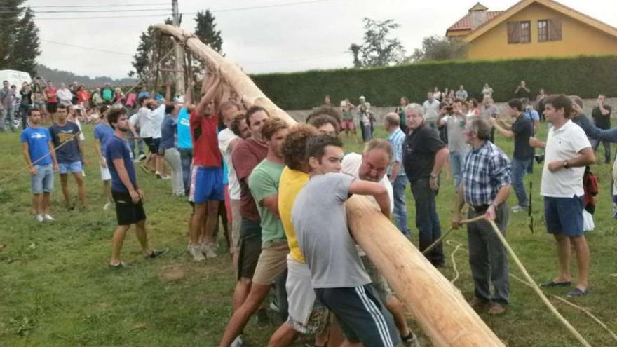 Los mozos, levantando la hoguera en Naves, ayer por la tarde.