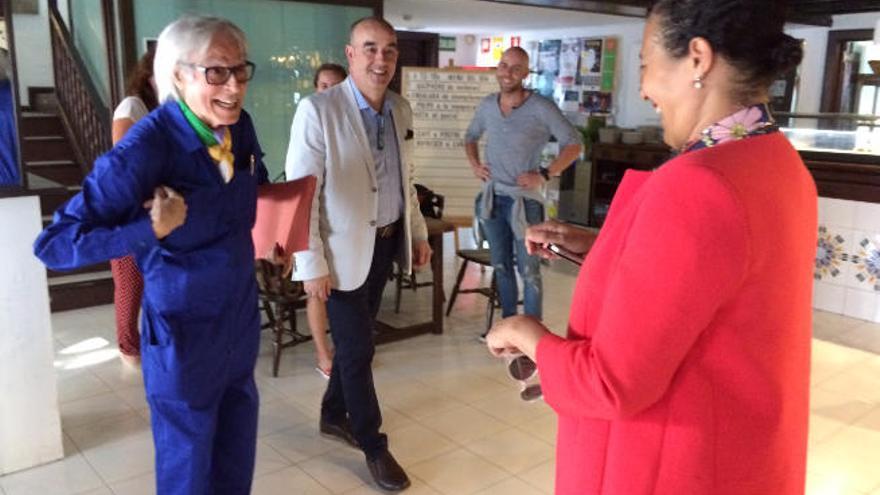 Pepe Dámaso (izquierda), ayer, muestra a Carmensa de la Hoz el mono que viste en recuerdo de Manrique y en presencia del crítico de arte Alfonso de la Torre en el bar de El Almacén.