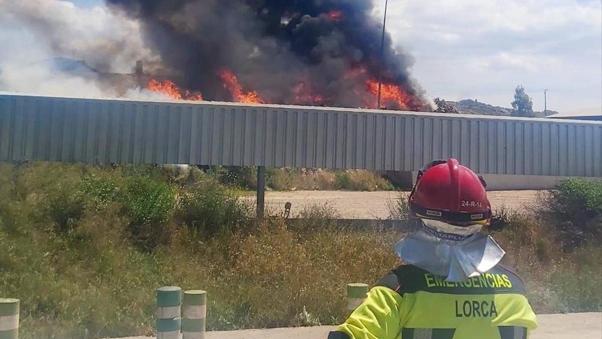 Un bombero trabaja para sofocar el fuego, que generó una gran columna de humo visible a kilómetros.