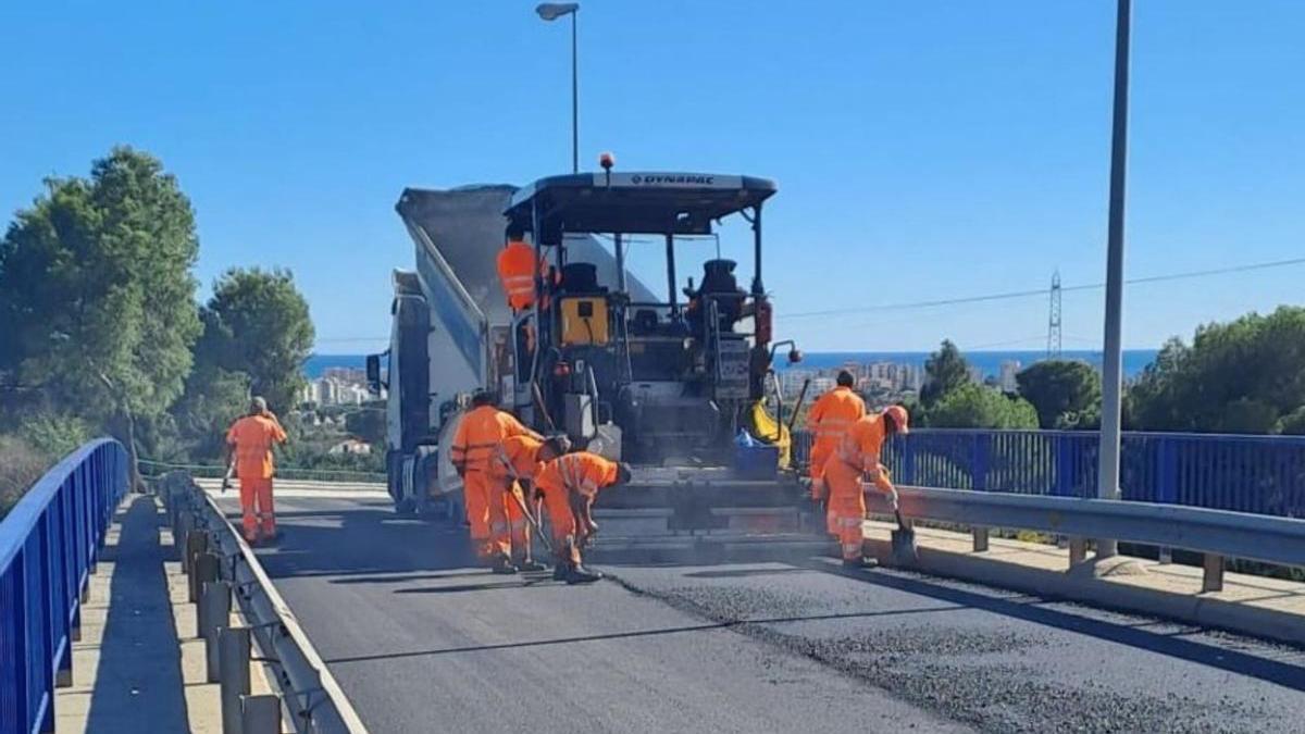 Operarios en los trabajos de asfaltado en el puente de urbanizaciones.