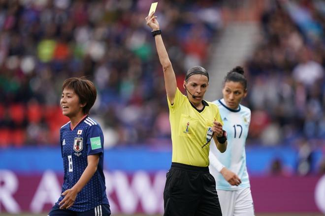 La árbitro francés Stephanie Frappart (C) muestra una tarjeta amarilla a la delantero de Japón, Mana Iwabuchi (L), durante el partido de fútbol del Grupo D de la Copa Mundial Femenina 2019 entre Argentina y Japón, en el Parc de Princes.