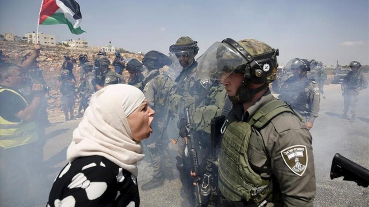 Una mujer palestina discute con un policía fronterizo israelí durante una protesta contra los asentamientos judíos en la aldea cisjordana de Nabi Saleh, cerca de Ramallah