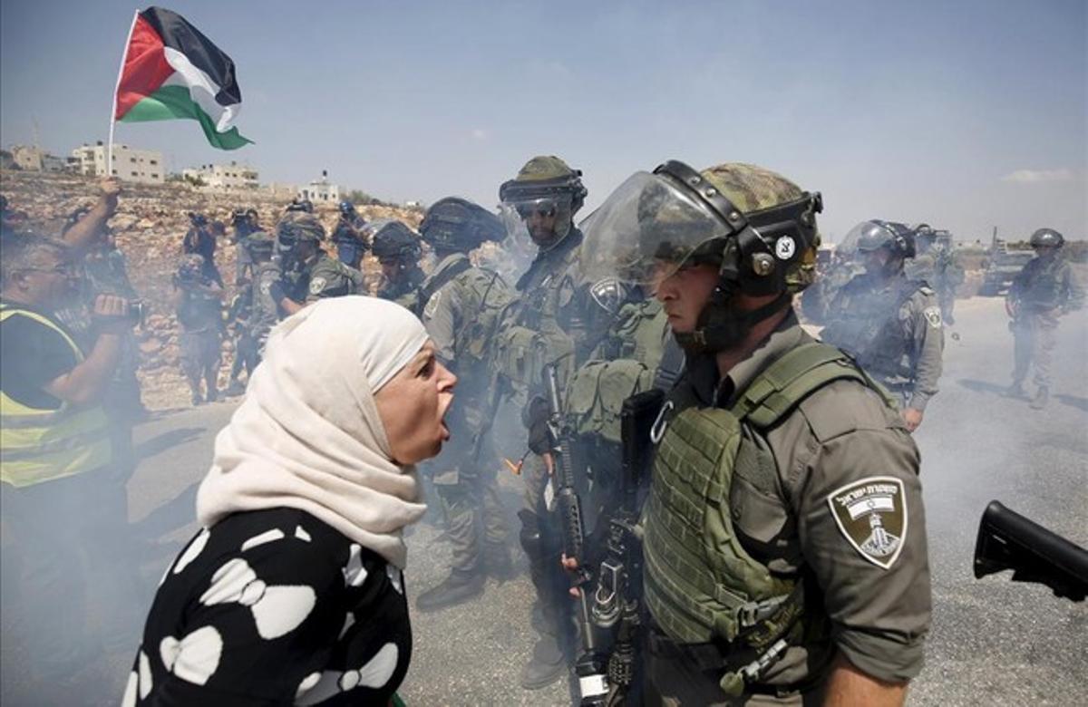 Una mujer palestina discute con un policía fronterizo israelí durante una protesta contra los asentamientos judíos en la aldea cisjordana de Nabi Saleh, cerca de Ramala.