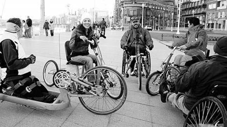 Algunos de los participantes, con sus «hand bikes» en el paseo de la playa. / aptaa