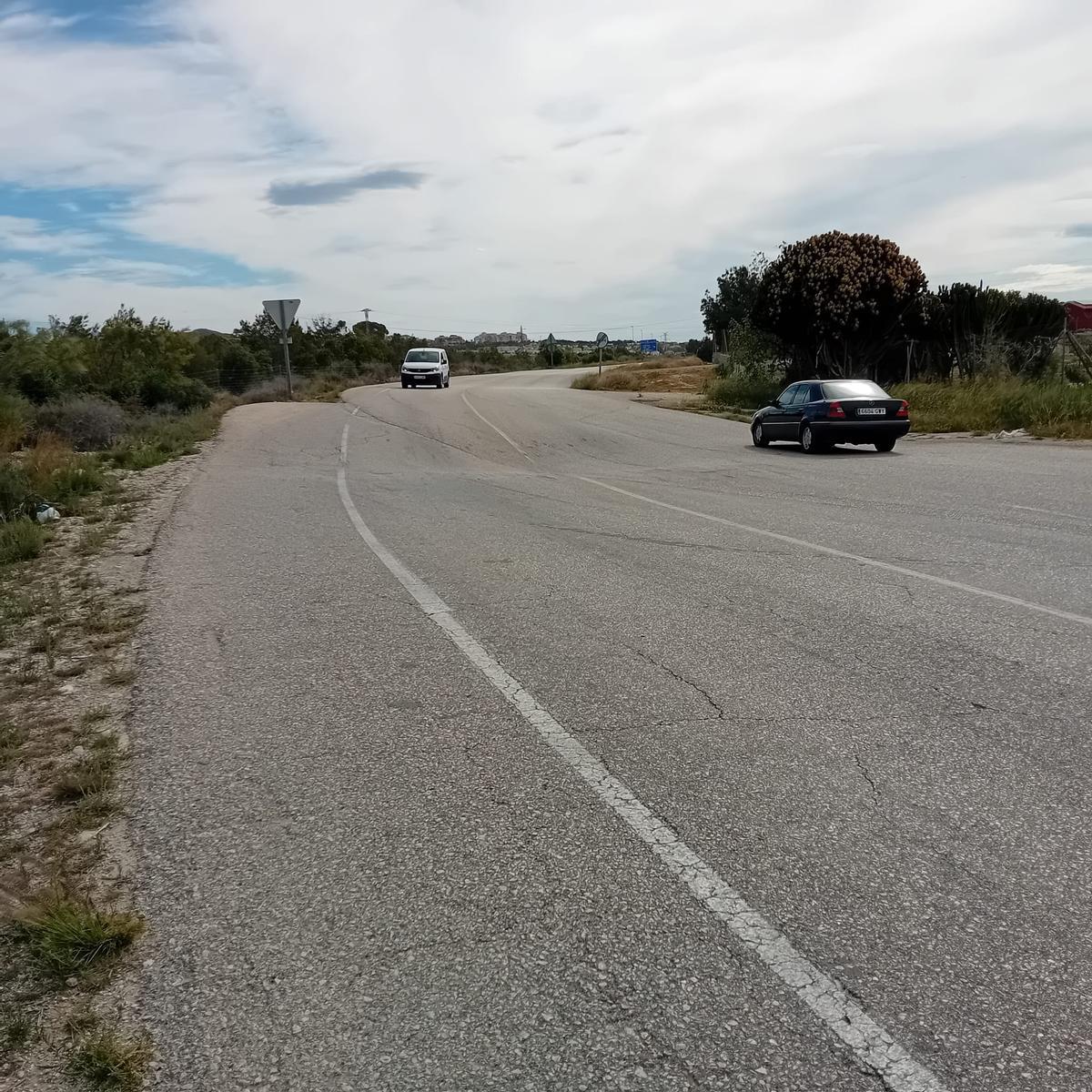 Dos vehículos circulan por la carretera, en la que se aprecia el hundimiento