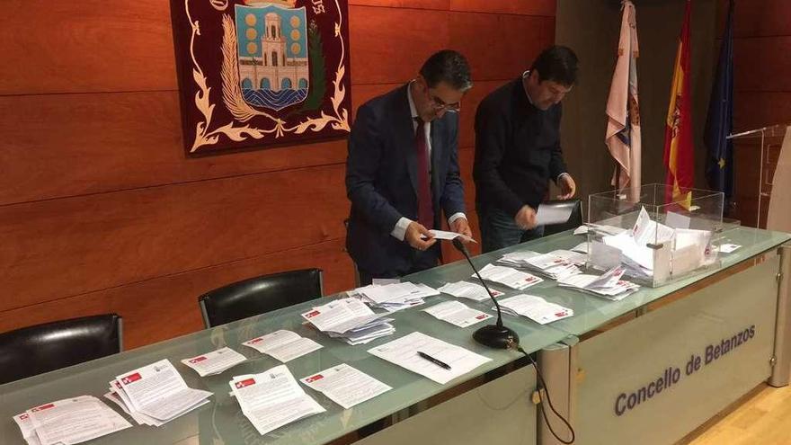 El concejal socialista Diego Fernández, al fondo, y el secretario municipal durante el recuento de votos.