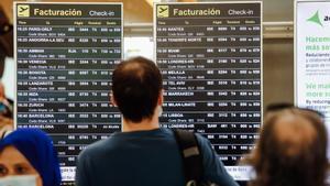 Pasajeros observan las pantallas con los vuelos de la Terminal 4 del Aeropuerto Adolfo Suárez Madrid Barajas.