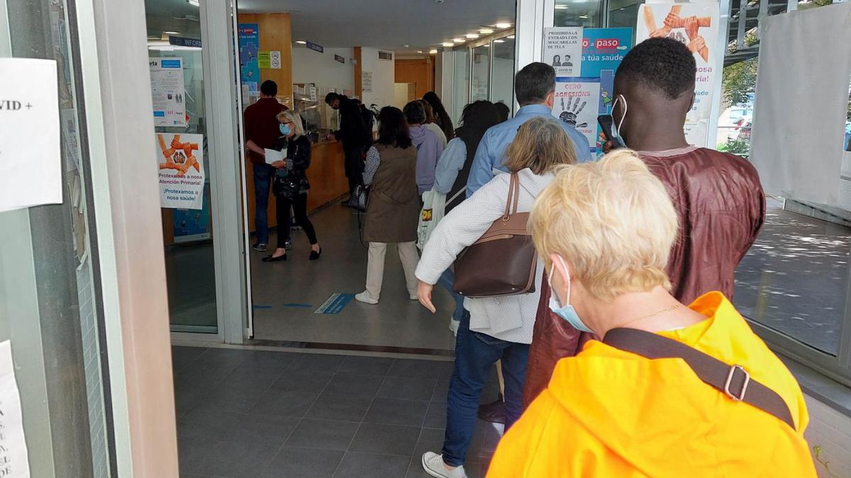 Pacientes esperan  en la entrada del centro de salud de A Doblada, en Vigo