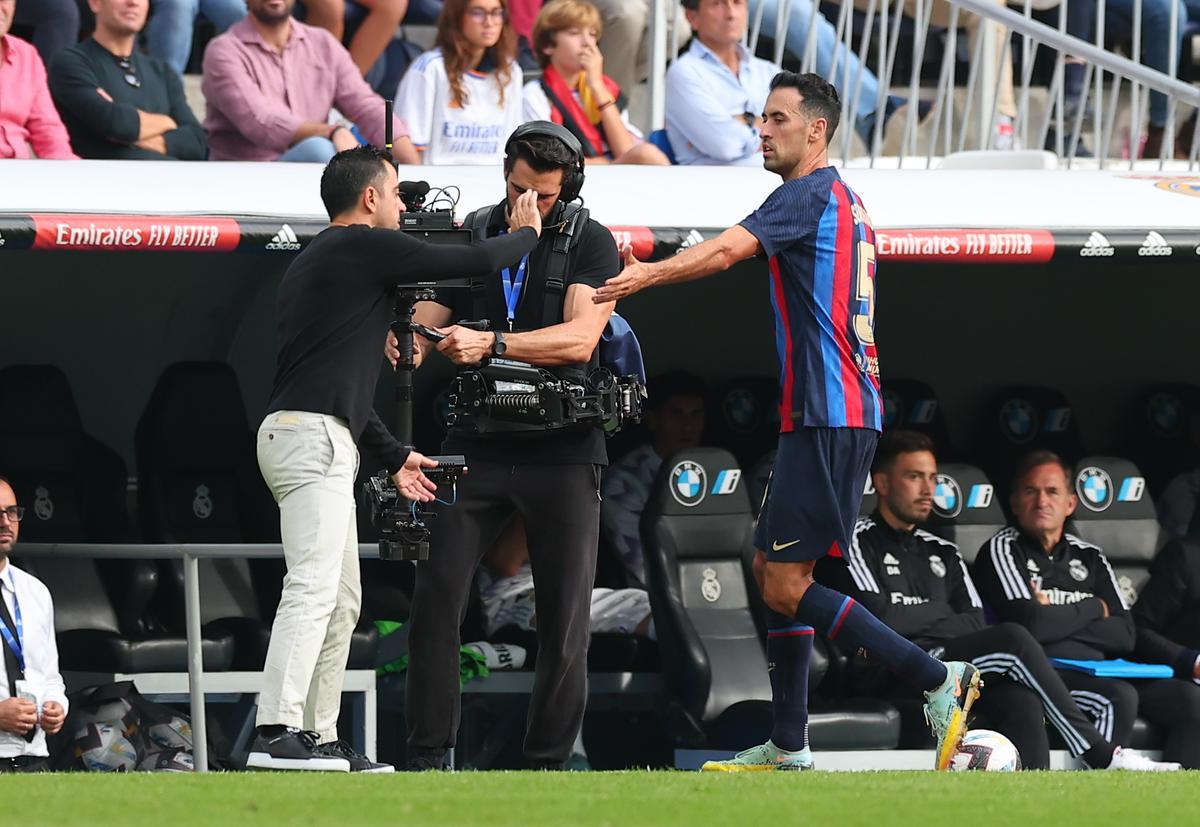 Xavi con Busquets en su sustitución durante el Real Madrid-Barça de La Liga 2022/23