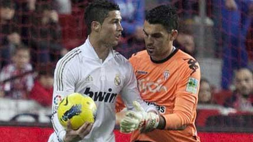 Juan Pablo intenta coger el balón que tiene Cristiano, en El Molinón.