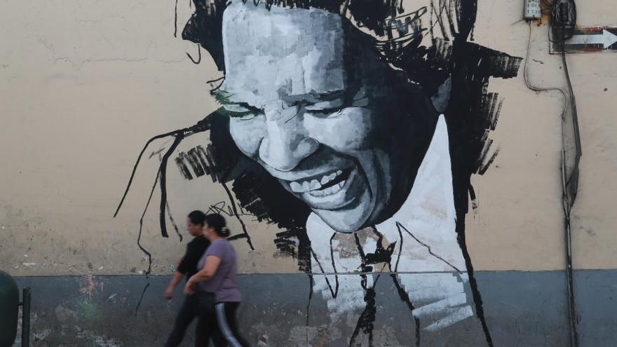 Dos ciudadanos pasean frente a un mural en Lima.