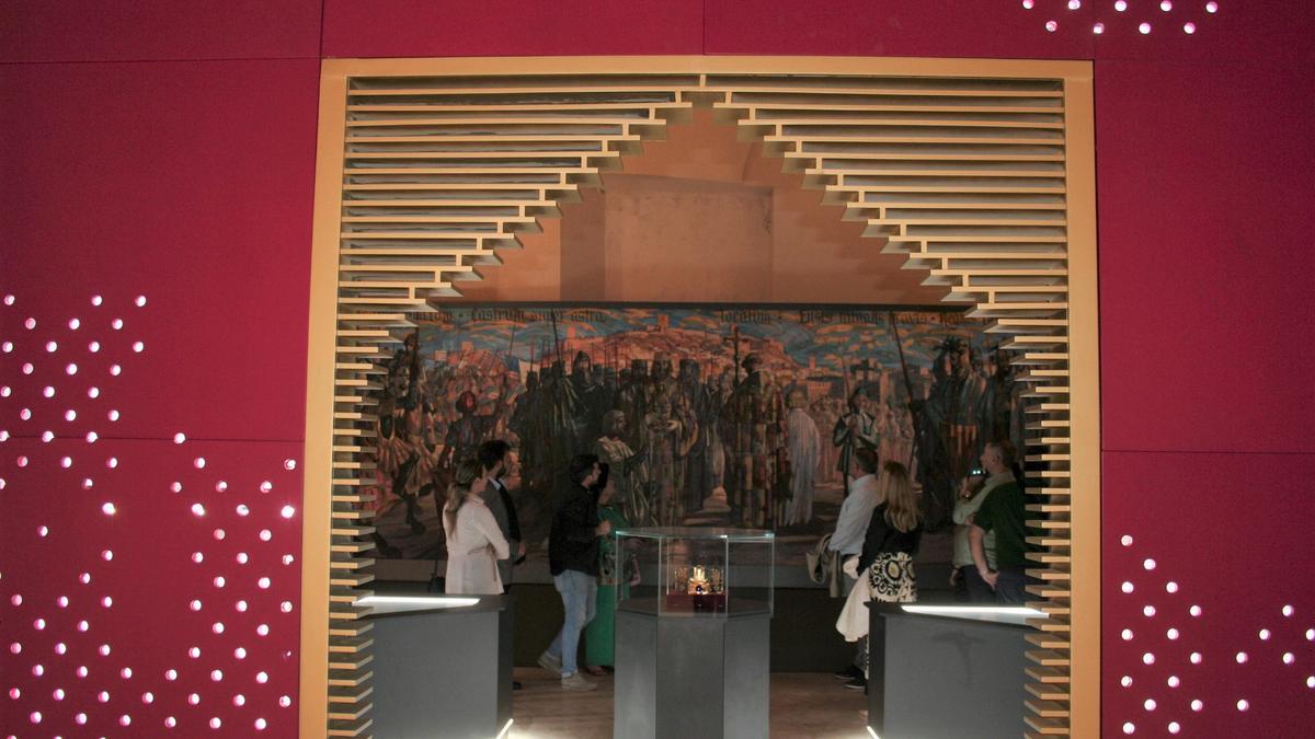 Entrada a la sala de Alfonso X que muestra, centrada, la vitrina con la corona de los camafeos y al fondo el cuadro de la Capitulación de la ciudad de Muñoz Barberán.