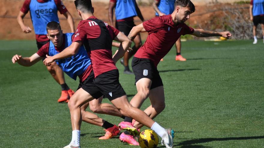 Darío Poveda controla un balón frente a dos compañeros en un entrenamiento.