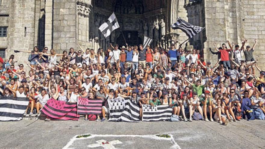 Un grupo de jóvenes de la Bretaña francesa (con sus banderas), ante la catedral de Tui, muestran su alegría por la inminente partida hacia Madrid con la JMJ.  // Marta G. Brea