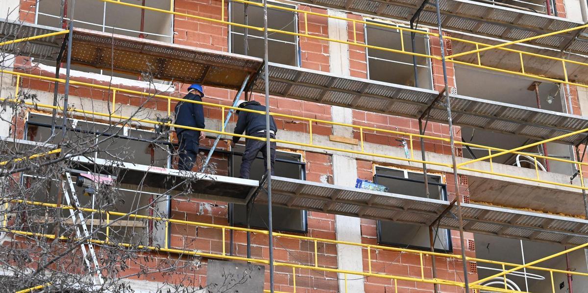 Dos albañiles trabajan en la construcción de un edificio en Castelló.