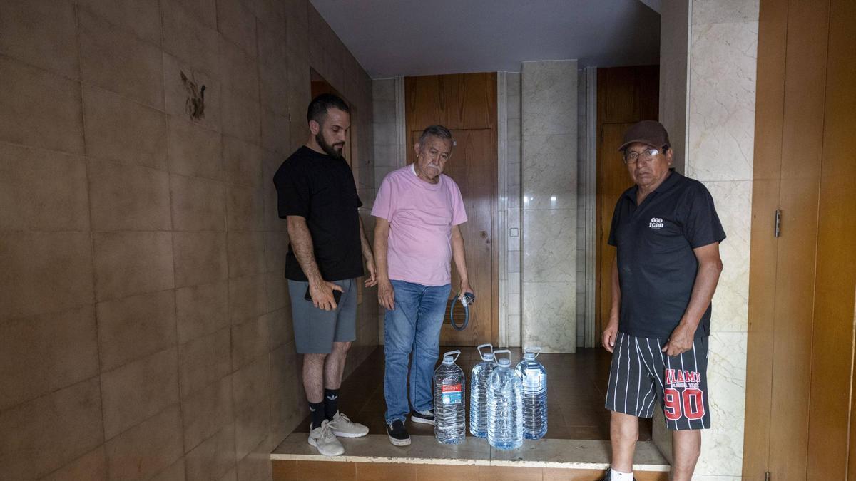Tres de los inquilinos afectados el pasado jueves con garrafas de agua.