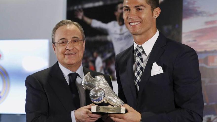 Florentino Pérez entrega un trofeo a Cristiano Ronaldo como recuerdo de su récord.