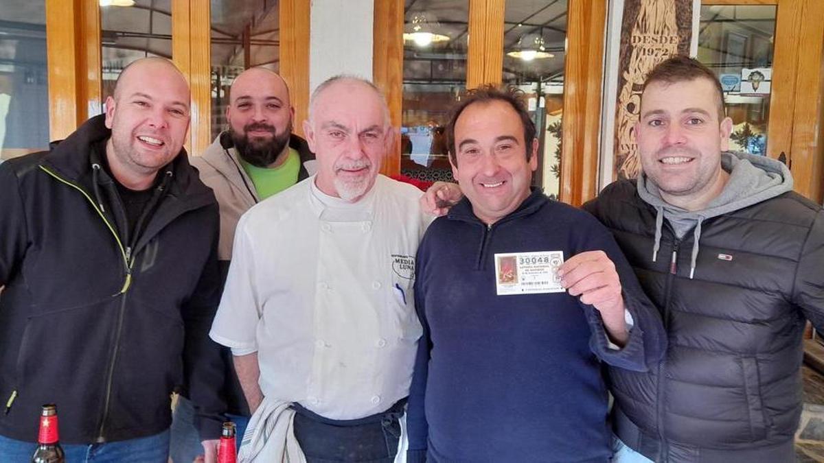 Un grupo de afortunados muestra el décimo agraciado en el sorteo.