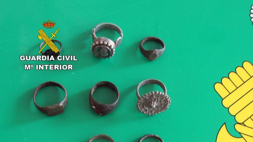 Algunas de las piezas recuperadas por la Guardia Civil, en las que se pueden ver anillos, monedas y una cruz.