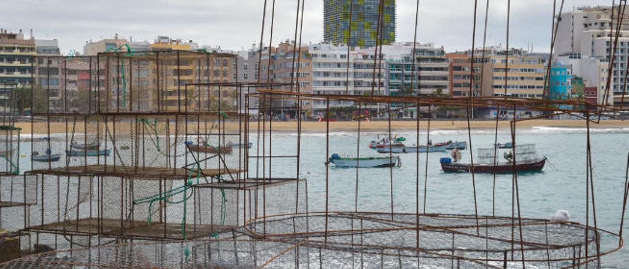 Las barquillas que fondean tradicionalmente en la playa de Las Cantaras, vistas a través de las nasas de pesca