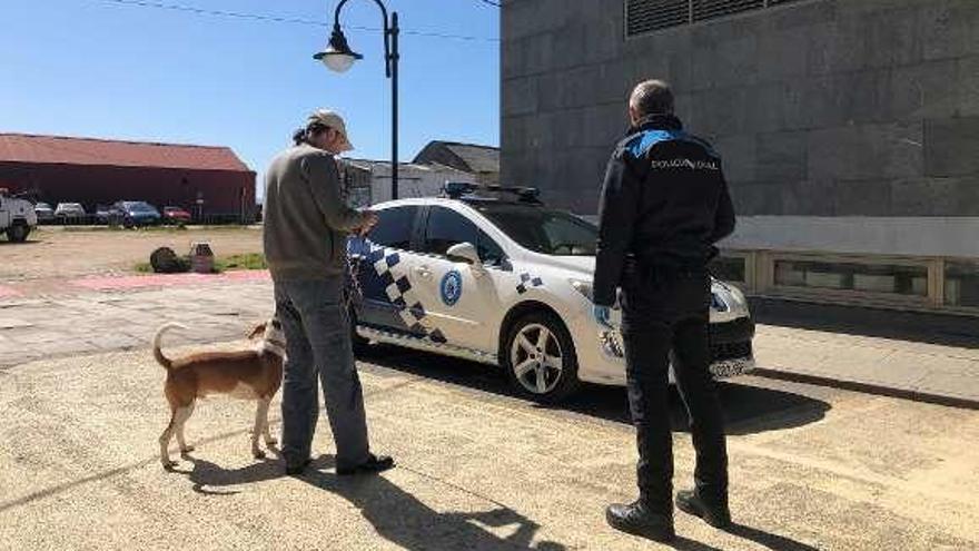 Un policía pide la documentación a un hombre con su perro. // G.N.