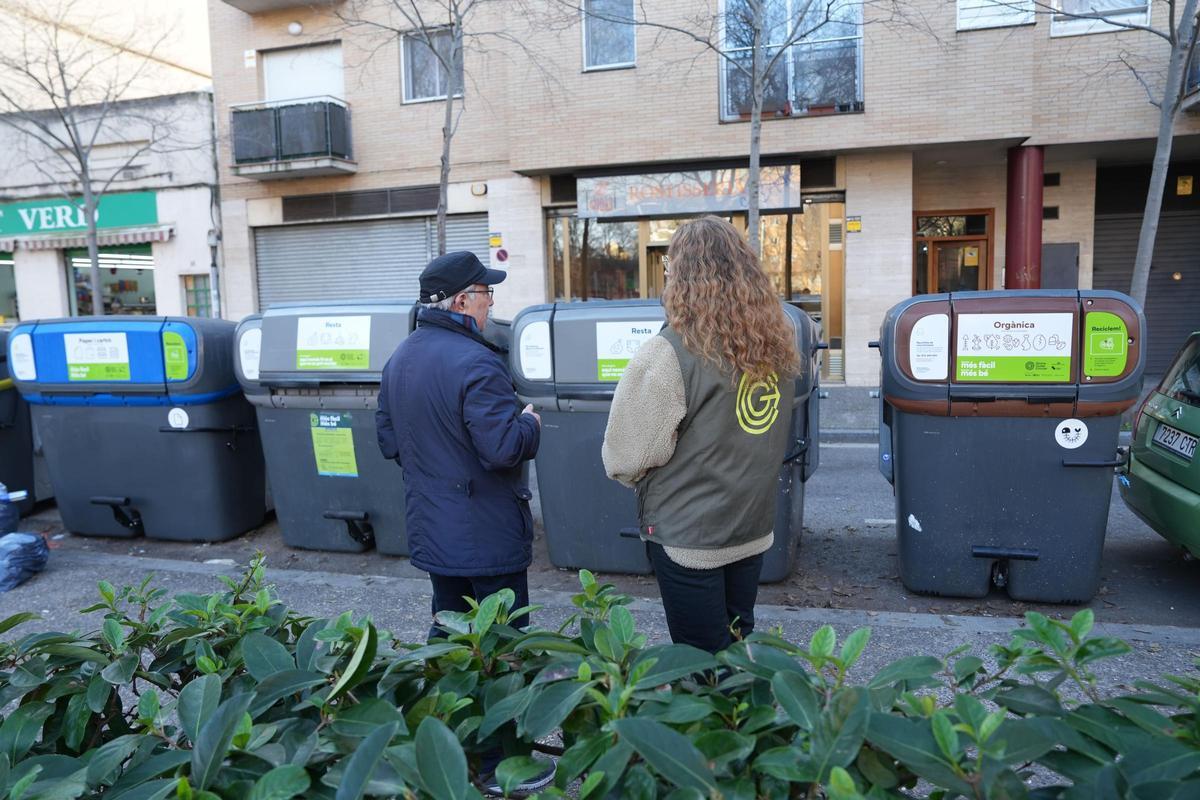 Dos educadors ambientals davant d'un contenidor