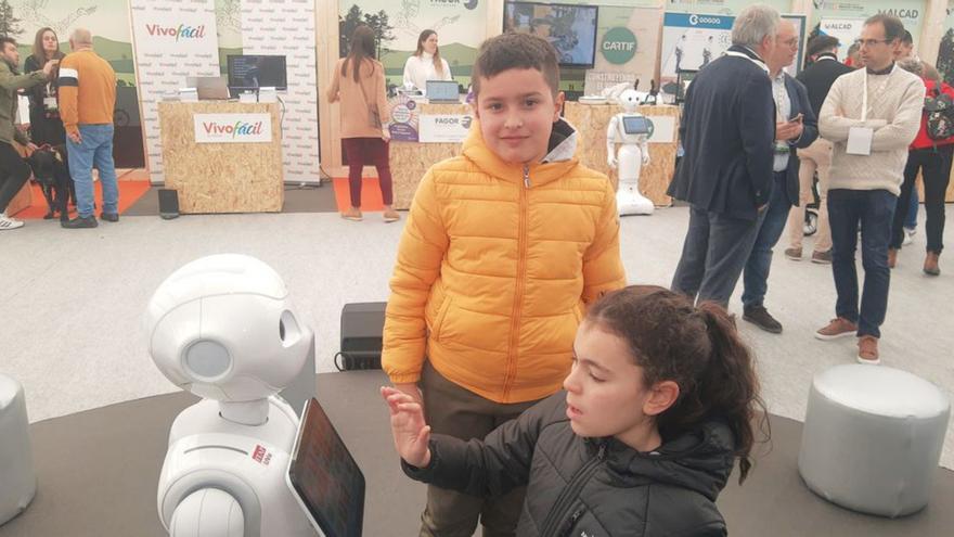 Abel Esteban Martín, de diez años, y María Teresa Blanco López, de 12, prueban las herramientas del robot «Copito» durante la jornada de puertas abiertas de Fitecu. | Araceli Saavedra