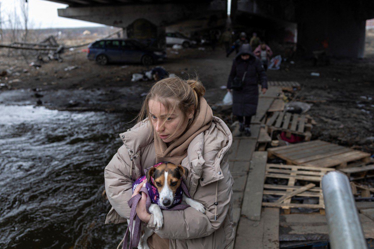 Una mujer lleva a un perro en brazos durante la evacuación de Kiev, en Ucrania.