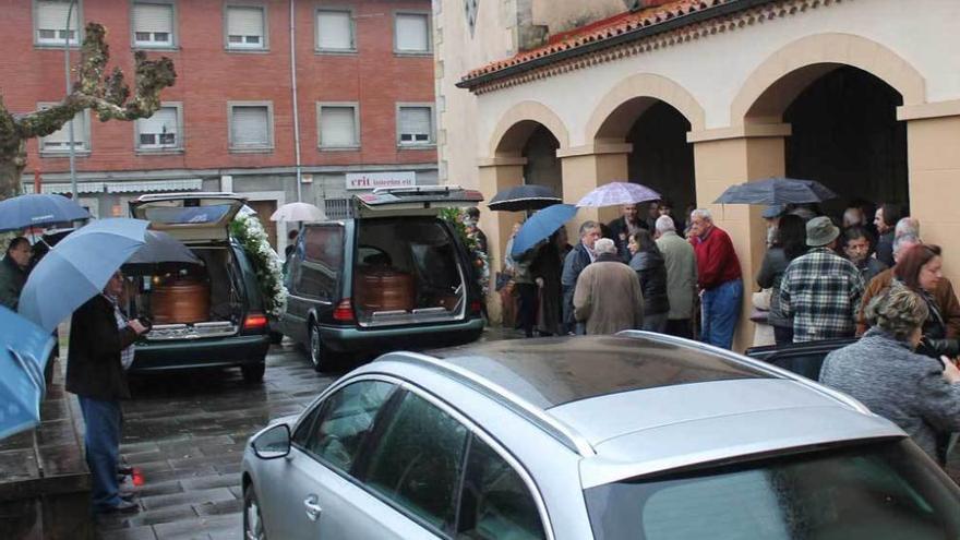 Arriba, los féretros llegando ayer a Villamayor. A la izquierda, una foto de la pareja de jóvenes.