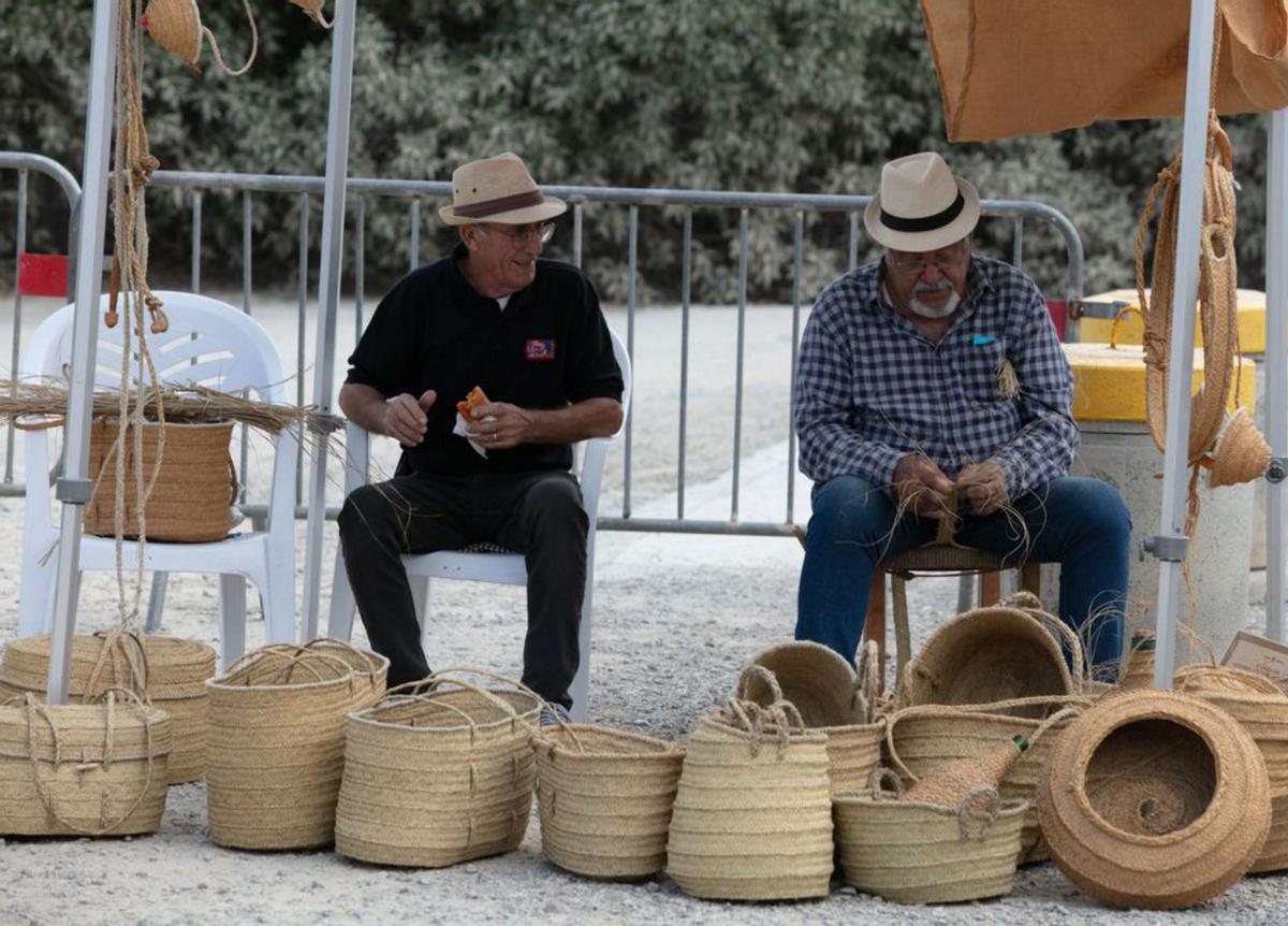 Dos hombres hacen senallons en la feria de artesanía. | VICENT MARÍ