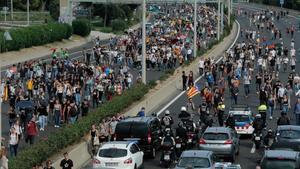 Manifestantes y viajeros caminan por la autopista camino del aeropuerto de El Prat.