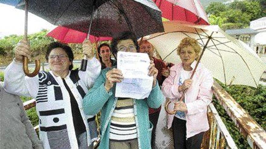 Los vecinos afectados muestran las providencias que recibieron ayer del juzgado vigués. / ricardo grobas