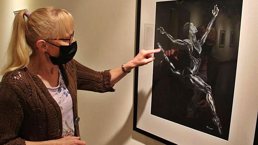 Carmen Méndez, con una de las obras de la exposición, en la Casa de Cultura de Vegadeo. | Tania Cascudo