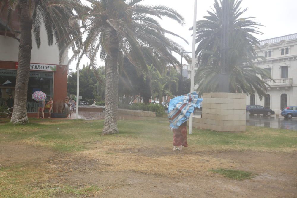 La lluvia sorprende a los bañistas en el Postiguet