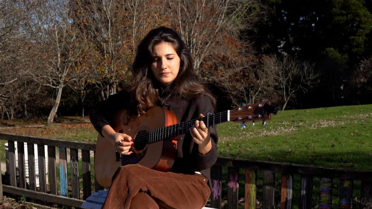 Lina de Sol tocando la guitarra en un parque compostelano