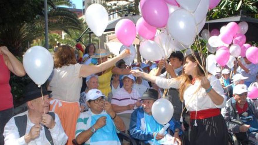 La voluntaria Elena Cabrera reparte globos entre los usuarios del centro sociosanitario El Pino. i SANTI BLANCO