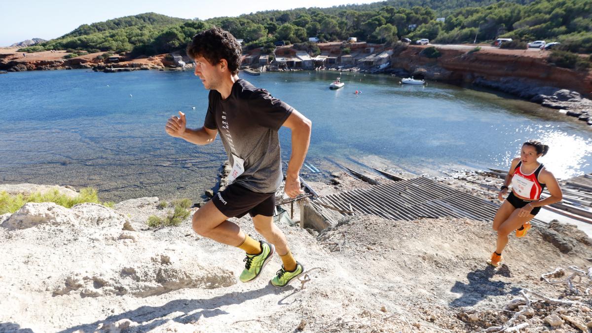 Dos deportistas suben por un acantilado de Ibiza en una prueba de trail.