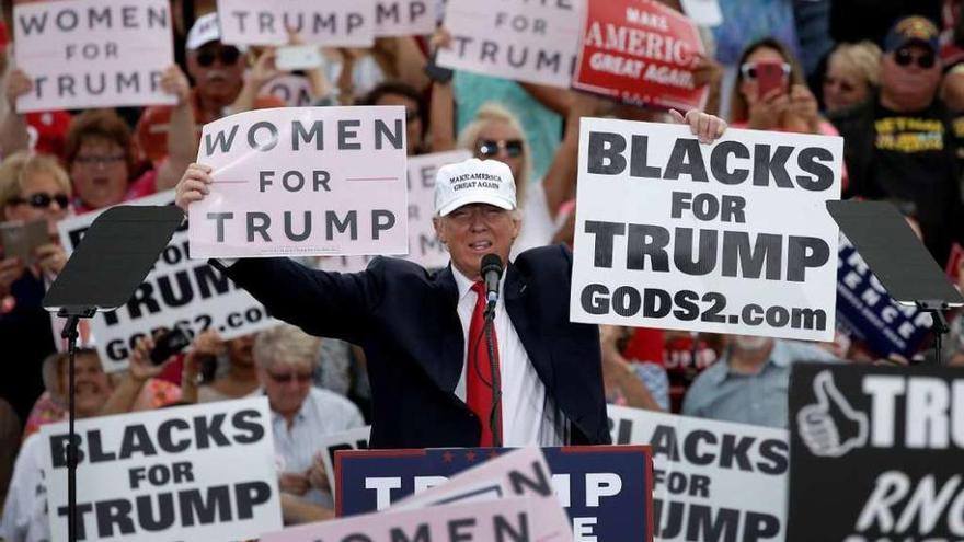 Trump muestra en Florida carteles de apoyo de mujeres y de negros a su candidatura. // Reuters