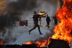 Un manifestante palestino lanza piedras contra los israelies