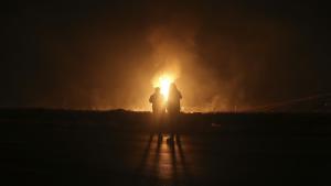 Dos hombres miran las llamas tras la explosión de un gasoducto en las afueras de la ciudad de Boroujen, Irán.