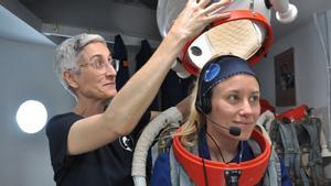 Neus Sabaté ayuda a Cesca Cufí Prat a prepararse para una salida extravehicular.