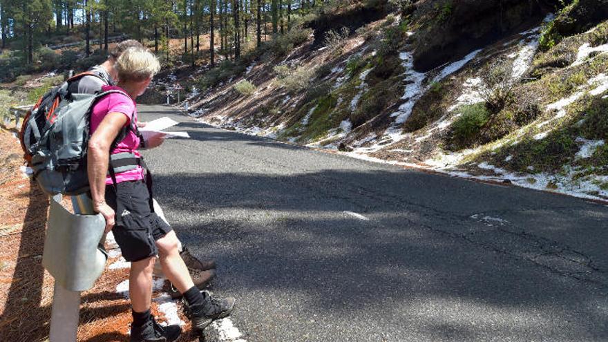 Dos caminantes observan los restos de granizo en la Cumbre.