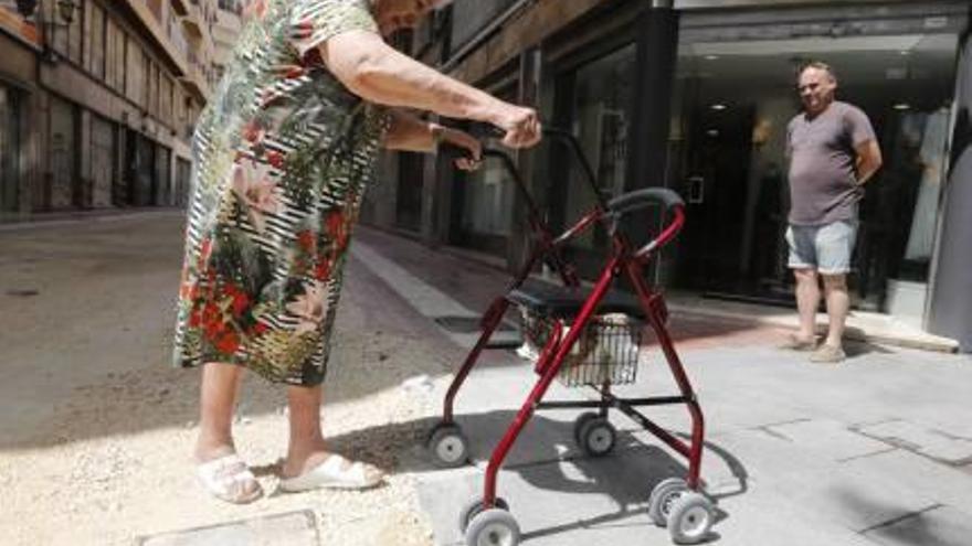 Una vecina con andador ayer por la zona rellenada con tierra.