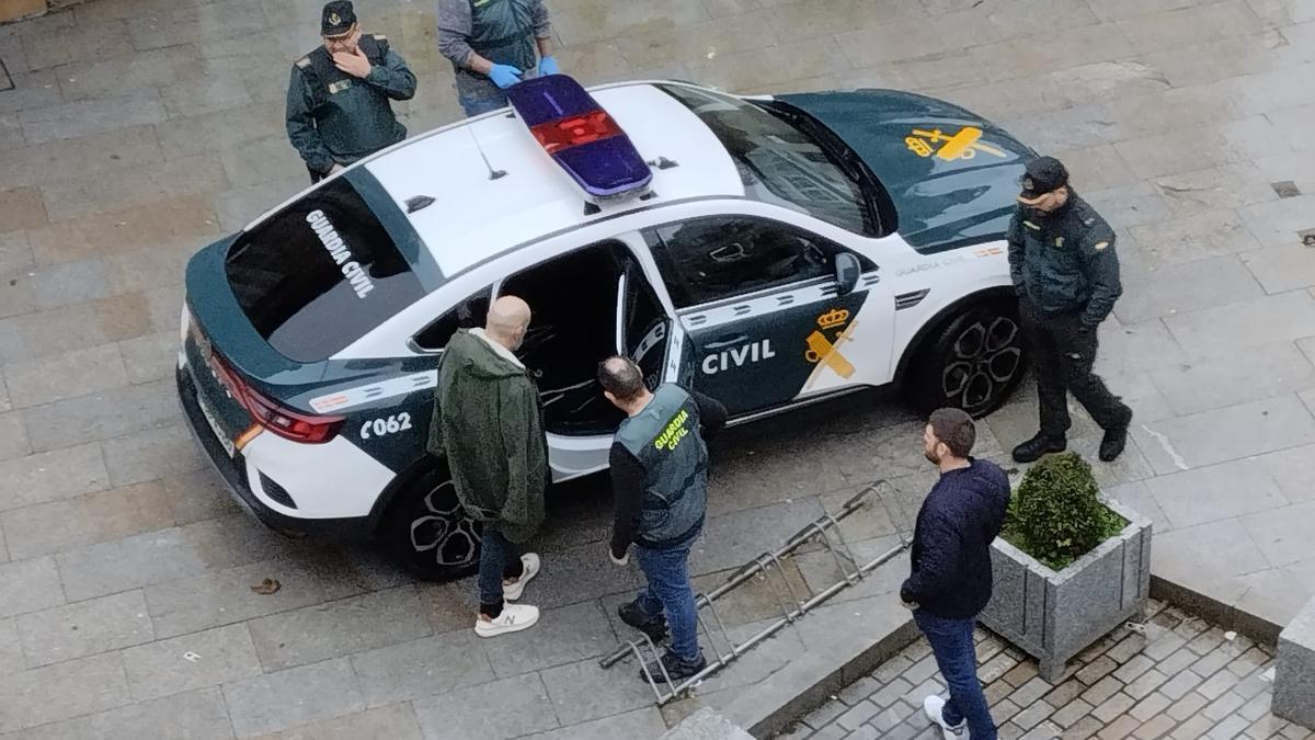 El detenido en el operativo es introducido en el vehículo de la Guardia Civil.