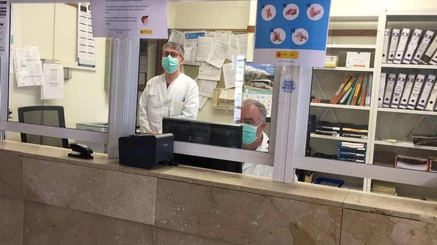 Trabajadores del centro de salud de Moaña, tras las pantallas de protección en el mostrador. // Fdv